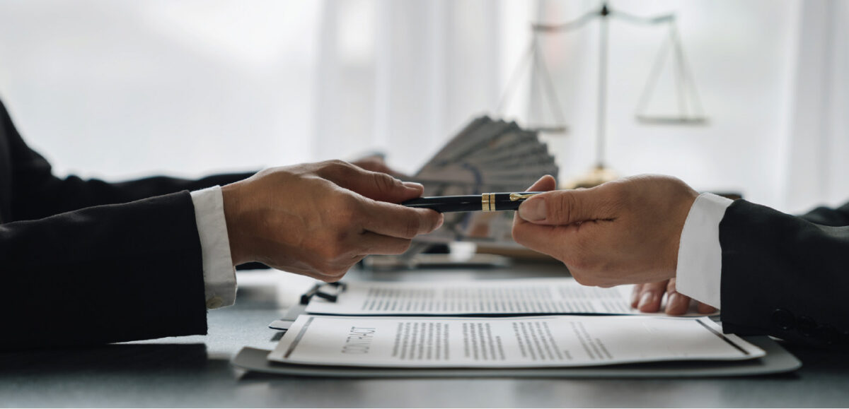 signing a document with a pen